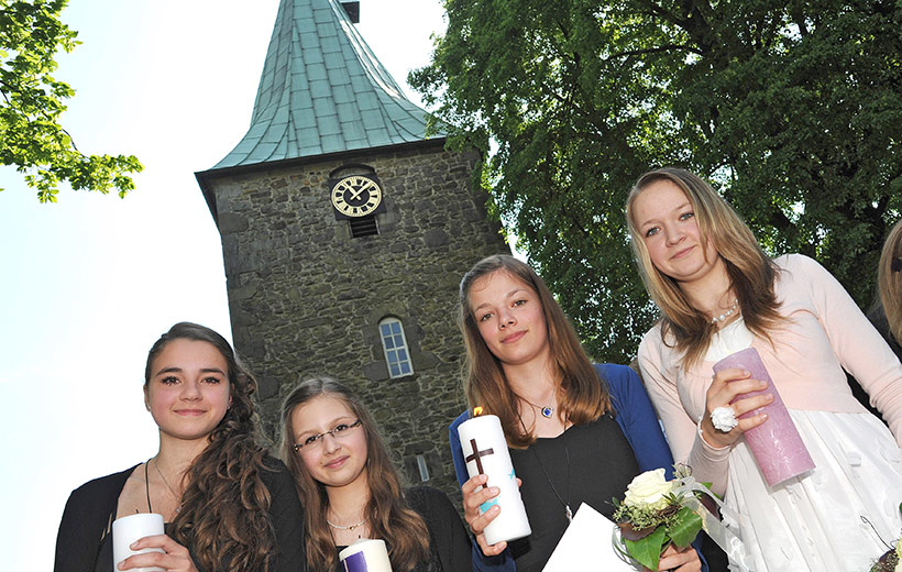 Konfirmanden stehen vor der Kirche