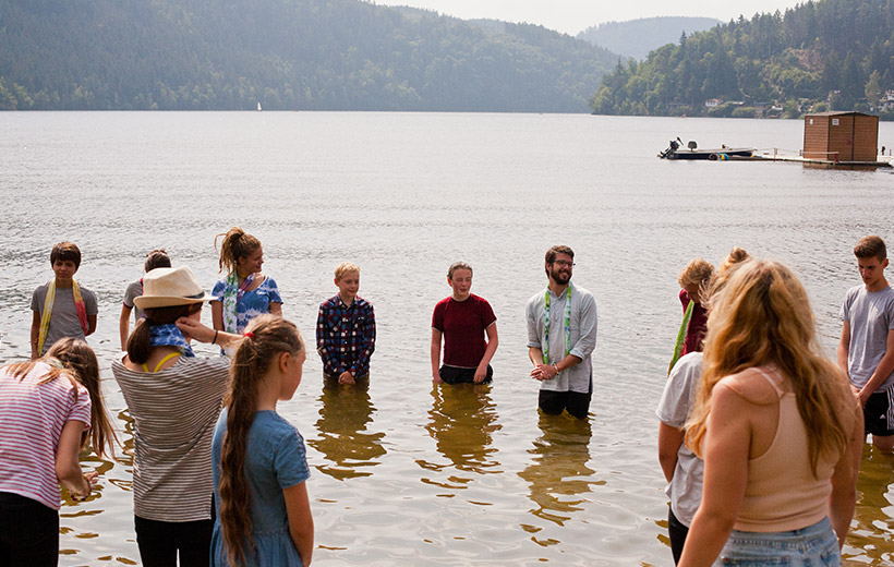 Das Bild zeigt Pfarrer Offenberger bei einer Taufe während des Konfi-Camps 2017.