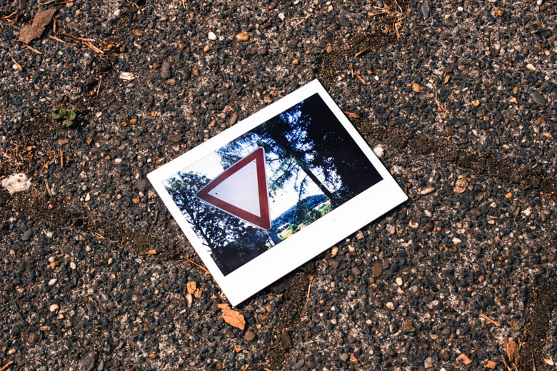 Polaroid mit „Vorfahrt gewähren“-Schild